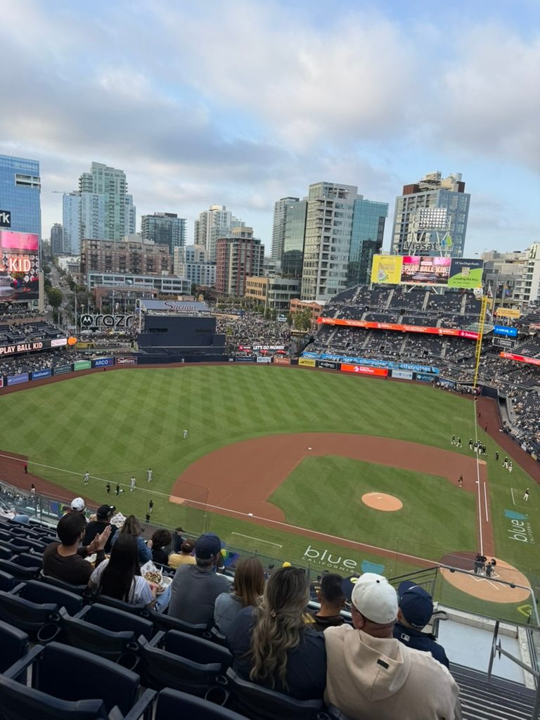 The view from the upper deck at Petco Park looking out over the field to the downtown San Diego skyline before a Padres game, with the bowl and outfield videoboard in frame